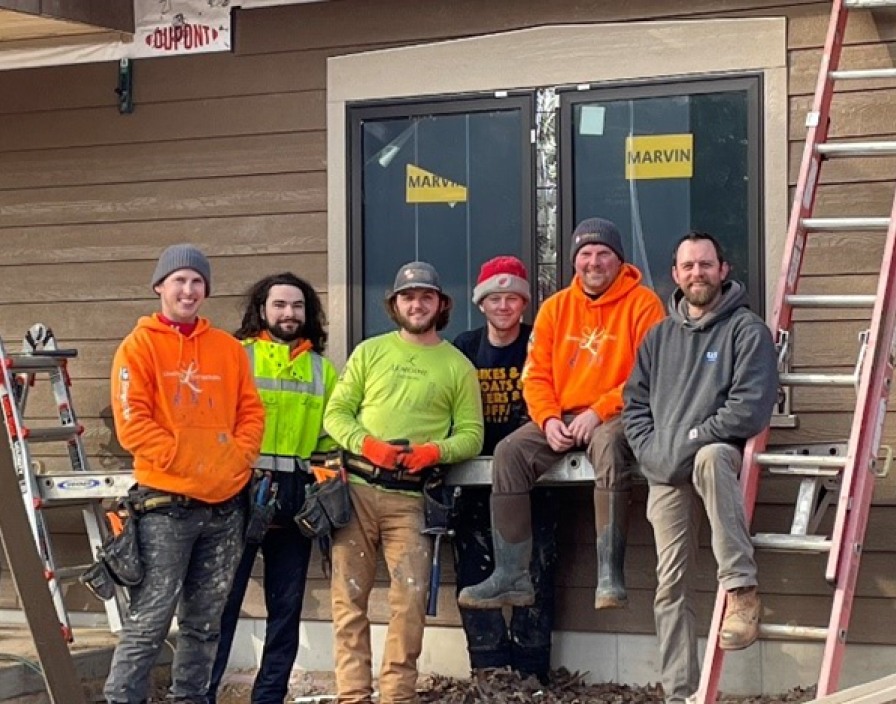 Six travailleurs sur un chantier posant pour une photo de groupe