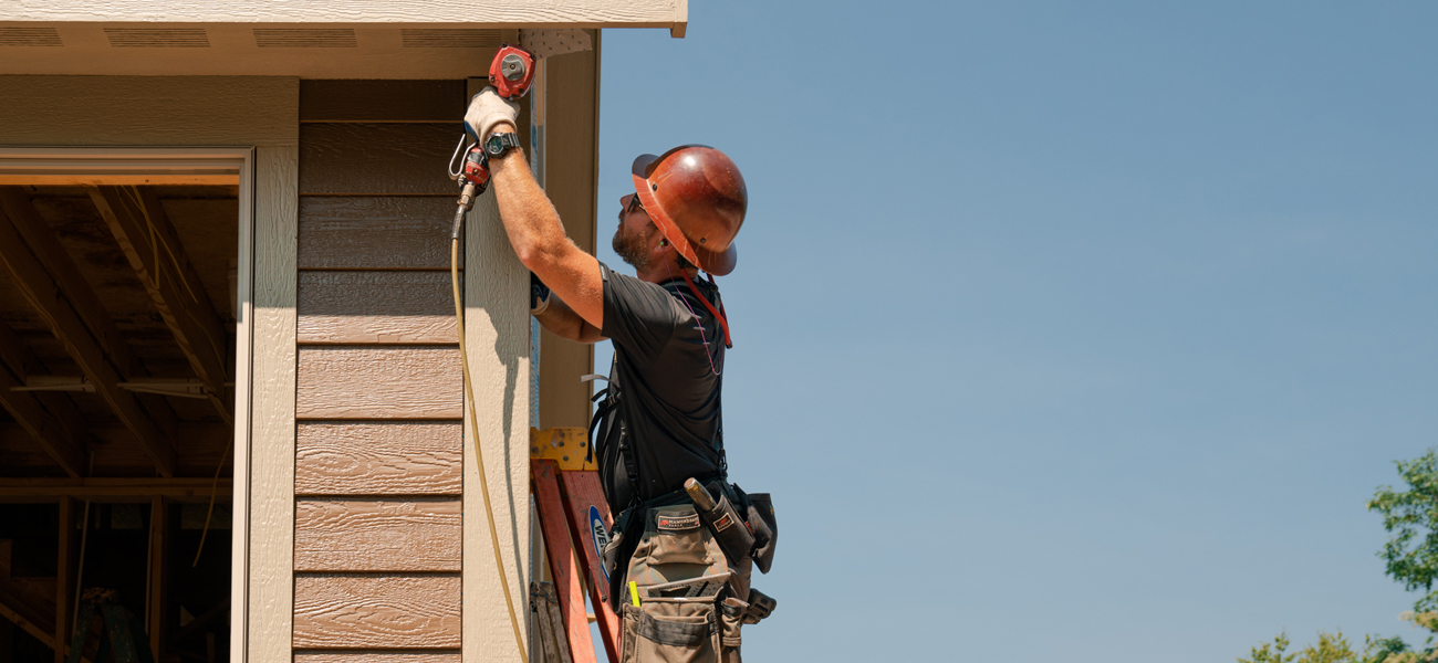 builder installing siding on side of garage