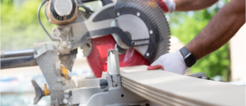 man using circular saw to cut siding