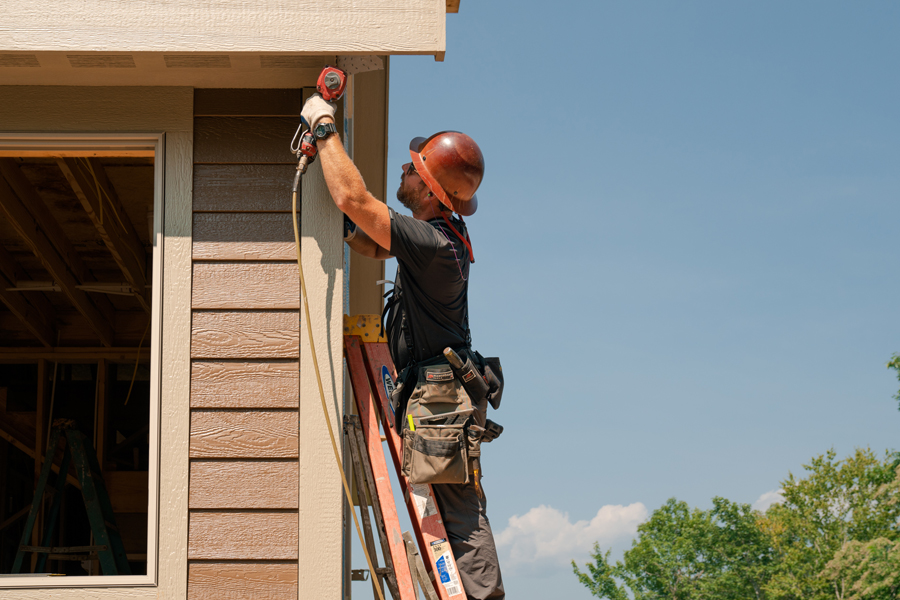 builder installing corner accessory on siding