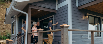 man using nail gun on siding