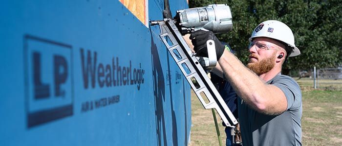 Instalador clavando paneles de pared WeatherLogic